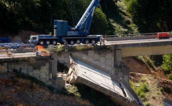 Operarios y grúas trabajan durante el desmontaje del tercer y último vano del viaducto de la A6