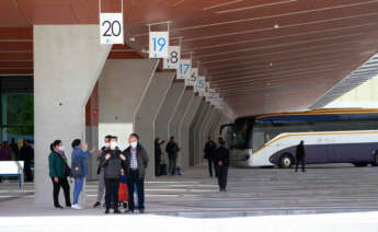 Varias personas esperan autobuses desde una de las dársenas de la estación de autobuses de Santiago de Compostela