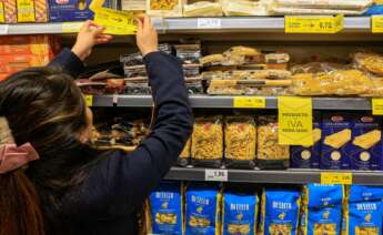 Una empleada de un supermercado coloca los carteles con los nuevos precios