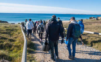 Voluntarios llegando a la playa de O Vilar para una jornada de limpieza tras la llegada de miles de bolitas de plástico procedentes del Tocomao / EFE/ Xurxo Martínez