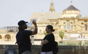 CÓRDOBA, 18/05/2022.- Dos turistas descansan y beben agua frente a la Mezquita -Catedral de Córdoba, hoy miércoles cuando se han alcanzado los 38 grados en la capital y la Aemet prevé ascenso de temperatura en Andalucía. EFE/Salas